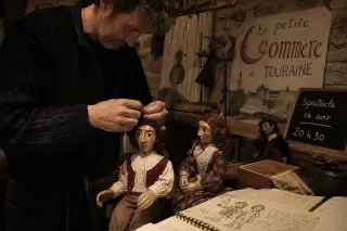 Backstage hands of a puppeteer adjusting marionettes in a dimly lit, rustic theater, surrounded by handmade props and rehearsal notes.